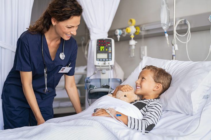 Happy,Young,Boy,Lying,On,Gurney,Talking,To,Friendly,Nurse.